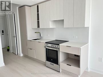 Mississauga (City Centre) condo for rent - A kitchen with white cabinets and a stove top oven.