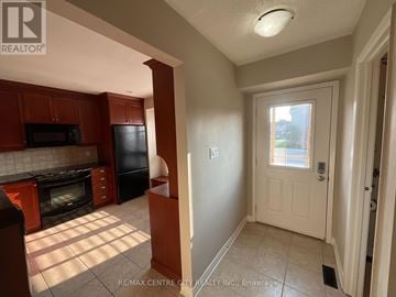 London South (South X) townhouse for rent - A kitchen with brown cabinets and a black fridge.