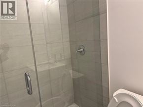 Kitchener townhouse for rent - A glass shower door with a handle is in the foreground.