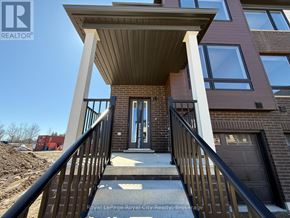 Guelph (Kortright East) townhouse for rent - A building with a balcony and a door is shown.