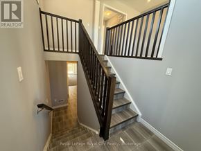 Guelph (Kortright East) townhouse for rent - A staircase with a black railing and wooden steps.