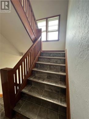 Sudbury apartment for rent - A staircase with a wooden railing and tiled steps leading up to a window.