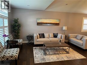Niagara Falls apartment for rent - A living room with a couch, chairs, and a painting on the wall.