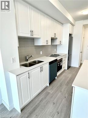 Hamilton condo for rent - A kitchen with white cabinets and a black dishwasher.