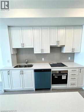 Hamilton condo for rent - A kitchen with white cabinets and a blue dishwasher.
