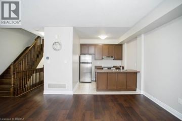 Oakville townhouse for rent - A kitchen with wooden cabinets and a stainless steel refrigerator.
