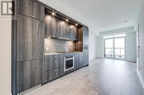 Toronto (Dovercourt-Wallace Emerson-Junction) condo for rent - A modern kitchen with wooden cabinets and a stainless steel oven.