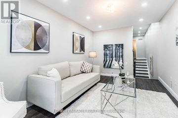 Brampton (Fletcher's Meadow) apartment for rent - A living room with a white couch, a glass coffee table, and a painting on the wall.