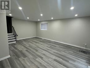 Toronto (Woburn) apartment for rent - A room with wooden flooring and a staircase on the left side.
