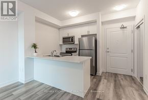 Hamilton (Waterdown) condo for rent - A kitchen with white cabinets and a stainless steel refrigerator.
