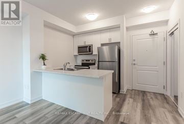 Hamilton (Waterdown) condo for rent - A kitchen with white cabinets and a stainless steel refrigerator.