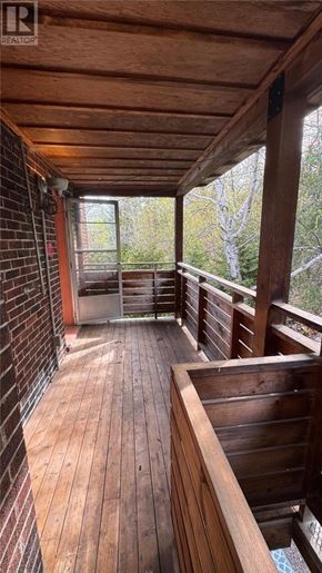 Sudbury apartment for rent - A wooden deck with a glass door leading to a balcony.