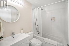 Niagara Falls (Arad/Fallsview) townhouse for rent - A white bathroom with a round mirror and a white bathtub.