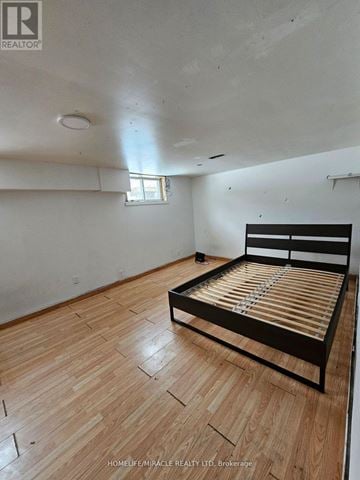 Toronto (Wexford-Maryvale) apartment for rent - A bedroom with a bed and wooden flooring.