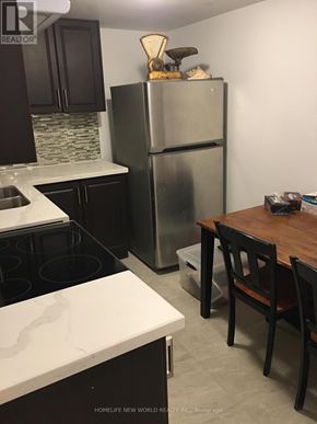 Toronto (Rockcliffe-Smythe) townhouse for rent - A kitchen with a refrigerator, stove, and table.