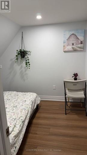 Toronto (Rockcliffe-Smythe) townhouse for rent - A bedroom with a bed, chair, and painting on the wall.