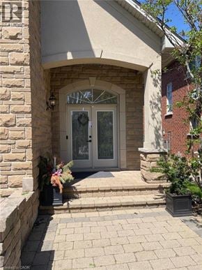 Hamilton apartment for rent - A white door with a glass window is flanked by two potted plants.