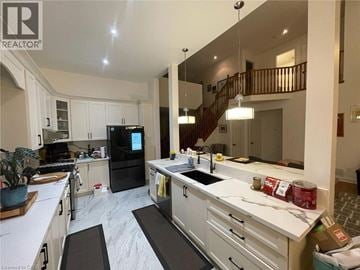 Hamilton apartment for rent - A kitchen with white cabinets and a black fridge.