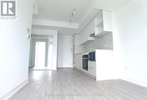 Toronto (Church-Yonge Corridor) condo for rent - A spacious kitchen with white cabinets and a wooden floor.