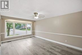 Hamilton (Vincent) apartment for rent - A room with a ceiling fan and a window showing a tree and a house.