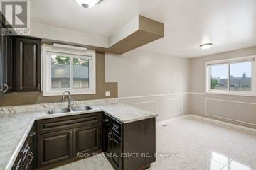 Hamilton (Vincent) apartment for rent - A kitchen with brown cabinets and a marble countertop.