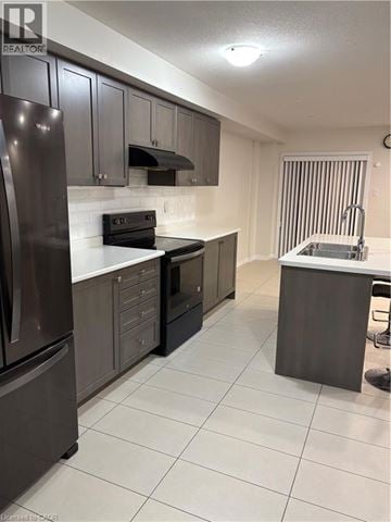 Stoney Creek townhouse for rent - A kitchen with a refrigerator, oven, and sink.