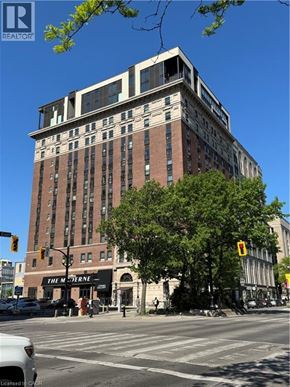 Hamilton condo for rent - A tall building with a sign that says "The M" in front of it.