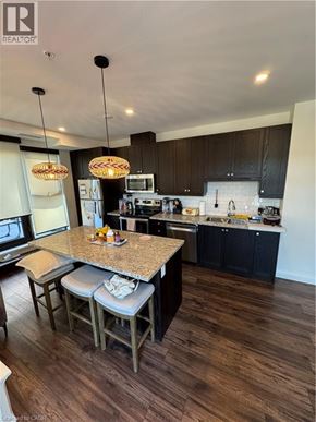 Hamilton condo for rent - A kitchen with a granite countertop and wooden floors.