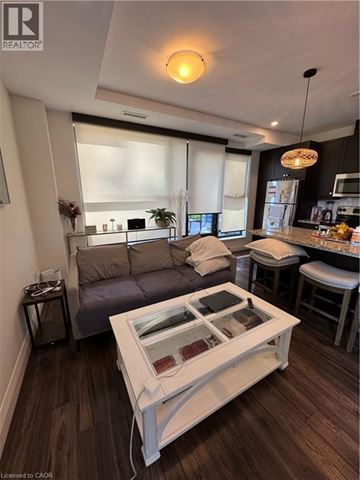 Hamilton condo for rent - A modern living room with a grey couch and a white coffee table.