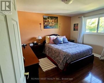 Whitby (Downtown Whitby) triplex for rent - A bedroom with a bed, nightstand, and lamp.