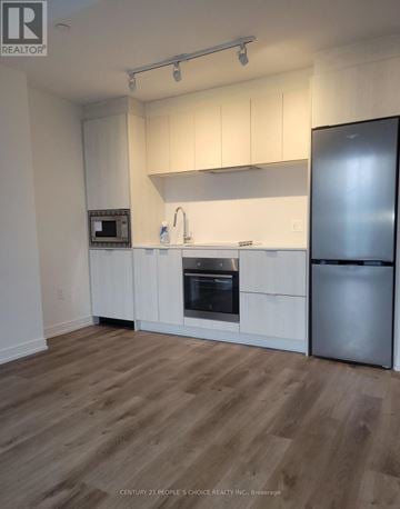 Hamilton (Beasley) condo for rent - A kitchen with white cabinets and a wooden floor.