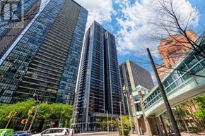 Toronto (Church-Yonge Corridor) condo for rent - A city street with tall buildings and a clear sky.