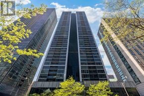 Toronto (Church-Yonge Corridor) condo for rent - A tall building with a dark facade stands between two other buildings with lighter facades.