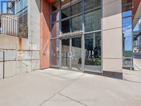 Toronto (Waterfront Communities) condo for rent - The image shows a building entrance with a glass door and a metal railing.