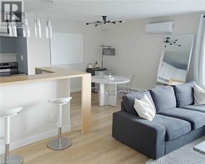 Toronto condo for rent - A modern living room with a grey sofa and a bar area.