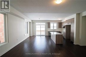 Barrie apartment for rent - A spacious living room with wooden floors and white walls.