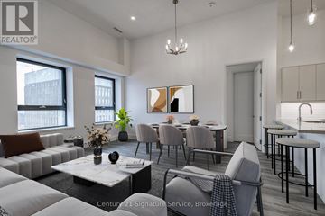 Hamilton (Beasley) condo for rent - A living room with a grey sofa, a coffee table, and a dining table with chairs.