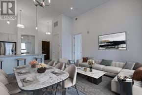 Hamilton (Beasley) condo for rent - A modern living room with a grey sofa, a round table and a painting on the wall.
