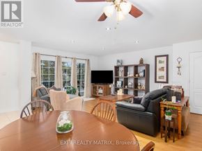 Russell condo for rent - A living room with a wooden table and chairs, a flat screen TV, and a ceiling fan.