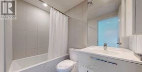 Toronto (Bay Street Corridor) condo for rent - A white bathroom with a tub, toilet, and sink.