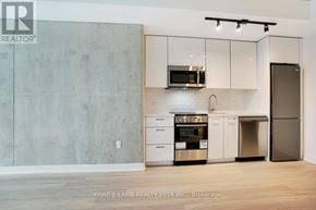 Toronto (Moss Park) condo for rent - A kitchen with a grey wall and white cabinets.