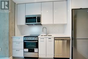 Toronto (Moss Park) condo for rent - A kitchen with white cabinets and a stainless steel refrigerator.