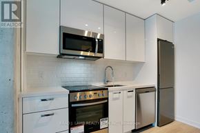 Toronto (Moss Park) condo for rent - A kitchen with white cabinets and a stainless steel refrigerator.
