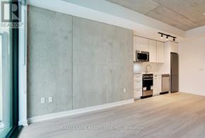 Toronto (Moss Park) condo for rent - A kitchen area with a microwave, oven, and cabinets.