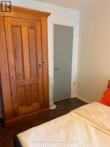 Toronto (Briar Hill-Belgravia) condo for rent - A bedroom with a bed, wooden wardrobe and a door.