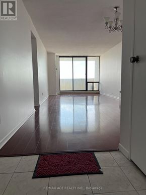Toronto (Newtonbrook West) condo for rent - A hallway with a red doormat and a chandelier.