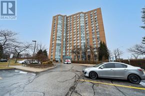 Toronto (Guildwood) condo for rent - A silver car is parked in a parking lot in front of a tall building.