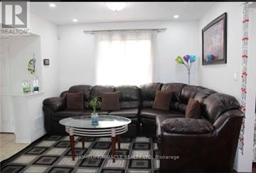 Brampton (Fletcher's Meadow) apartment for rent - A living room with a brown leather couch and a glass coffee table.
