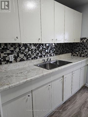 Toronto (Wexford-Maryvale) multi-family for rent - A kitchen with white cabinets and a sink.