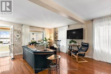Brockville apartment for rent - A living room with a black couch and a television on the wall.
